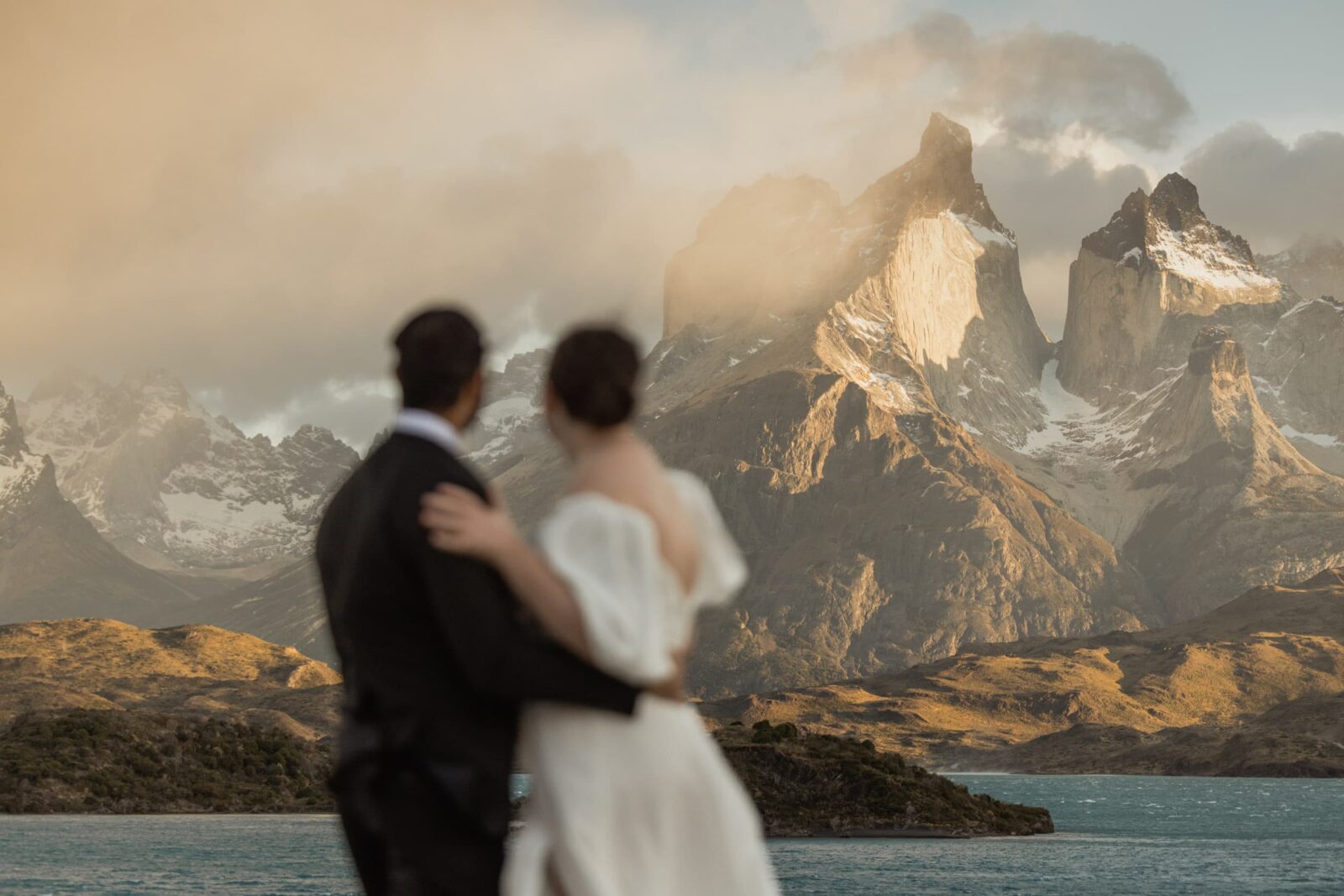 elopement couple looking out at the sunrise light on mountains at Torres del Paine National Park